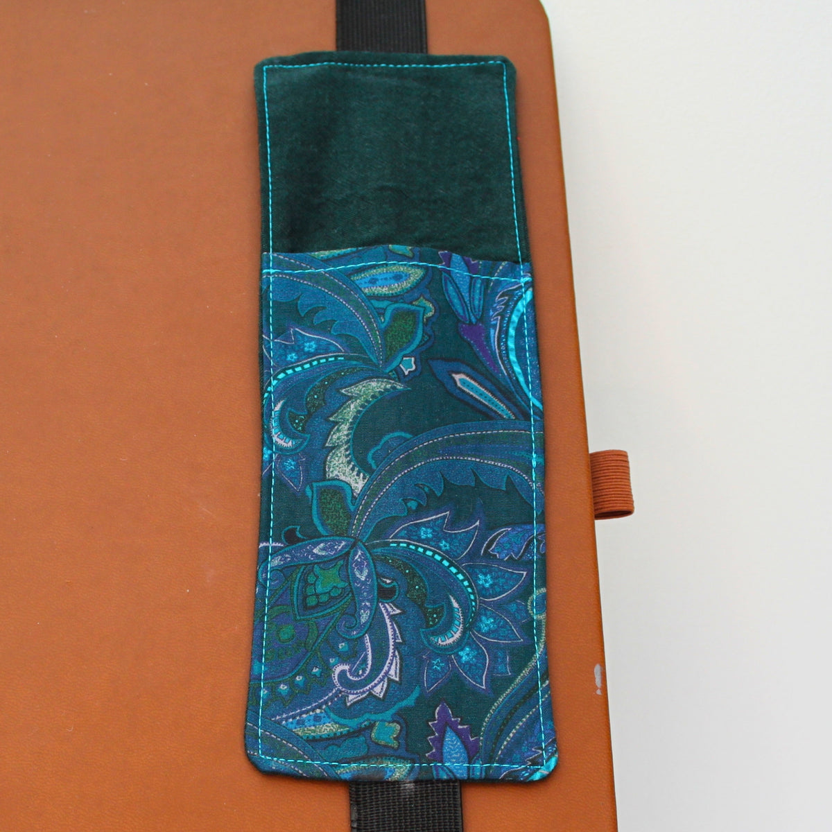 Handmade A4 fabric notebook pen pocket in Electric blue and pink paisley against green - black elastic — Dark Star Stitches 