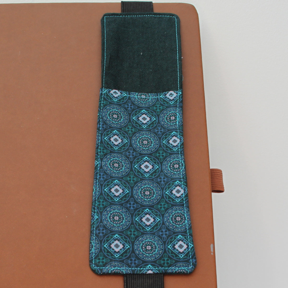 Handmade A4 fabric notebook pen pocket in Electric blue and pink diamonds and circles against green - black elastic — Dark Star Stitches 