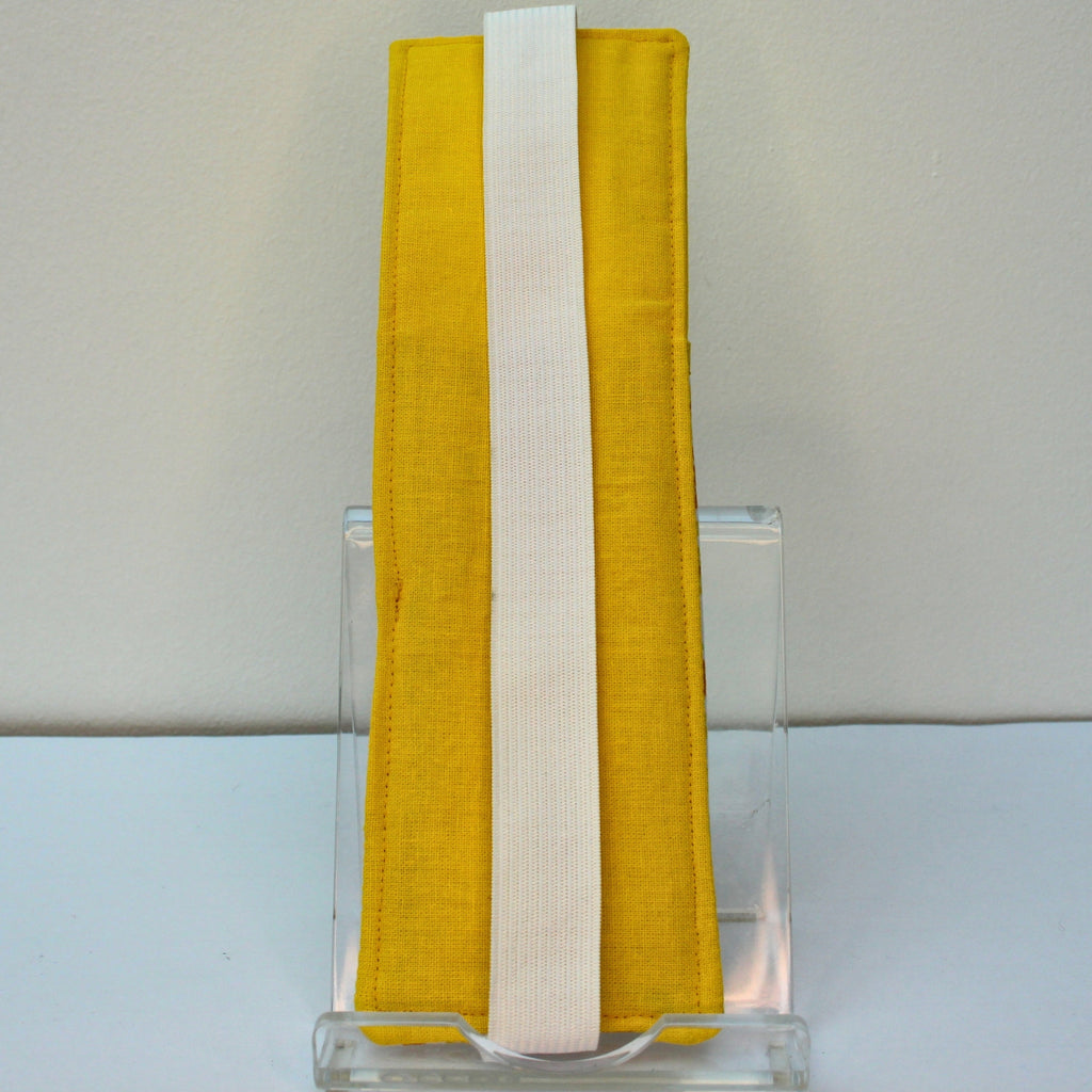 Reverse of handmade A5 fabric notebook pen pocket in yellow and orange floral, white elastic — Dark Star Stitches