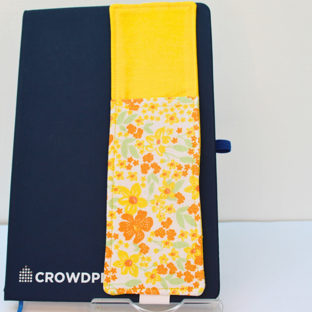 Handmade A5 fabric notebook pen pocket in yellow and orange floral, white elastic — Dark Star Stitches