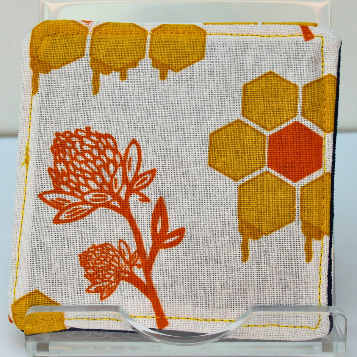 Reverse of handmade fabric bookmark in bee yellow and orange honeycomb with orange plant corner and back, dark blue inner — Dark Star Stitches