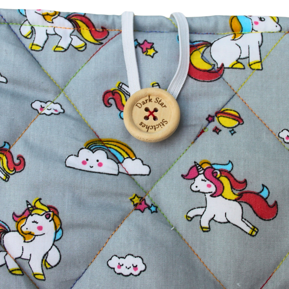 Close-up of button closure on handmade quilted booksleeve in grey unicorn cotton fabric