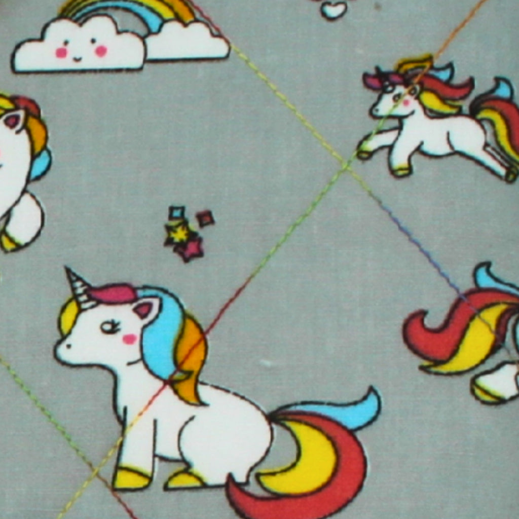 Close-up of cartoon unicorn pattern on grey cotton fabric used in handmade quilted booksleeve set
