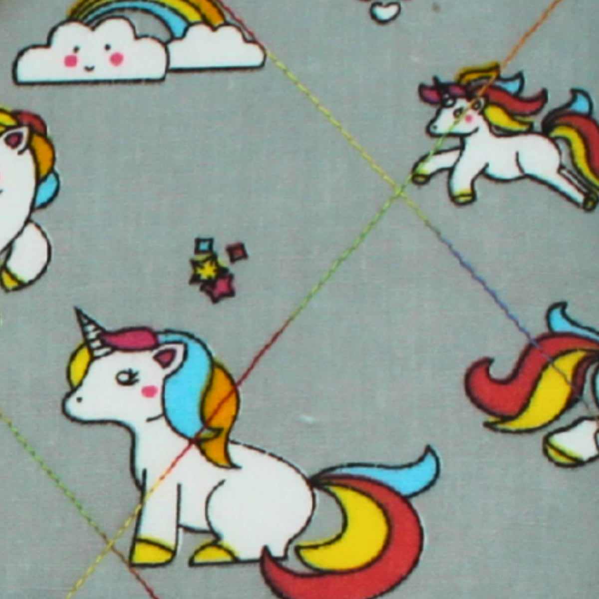 Close-up of cartoon unicorn pattern on grey cotton fabric used in handmade quilted booksleeve set