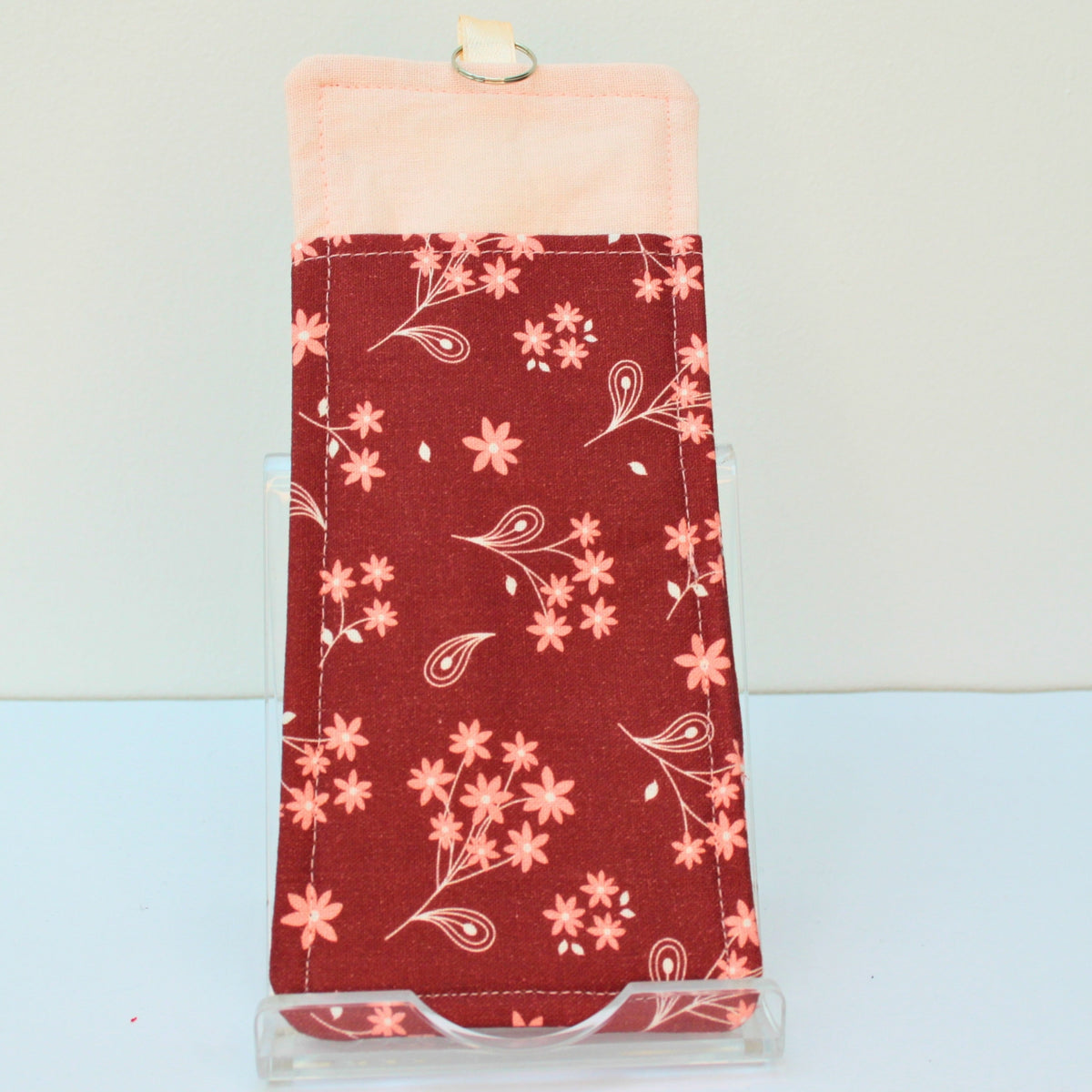 Reverse of handmade double sided lanyard pocket in pink flowers on burnt red fabric, pale pink ribbon — Dark Star Stitches