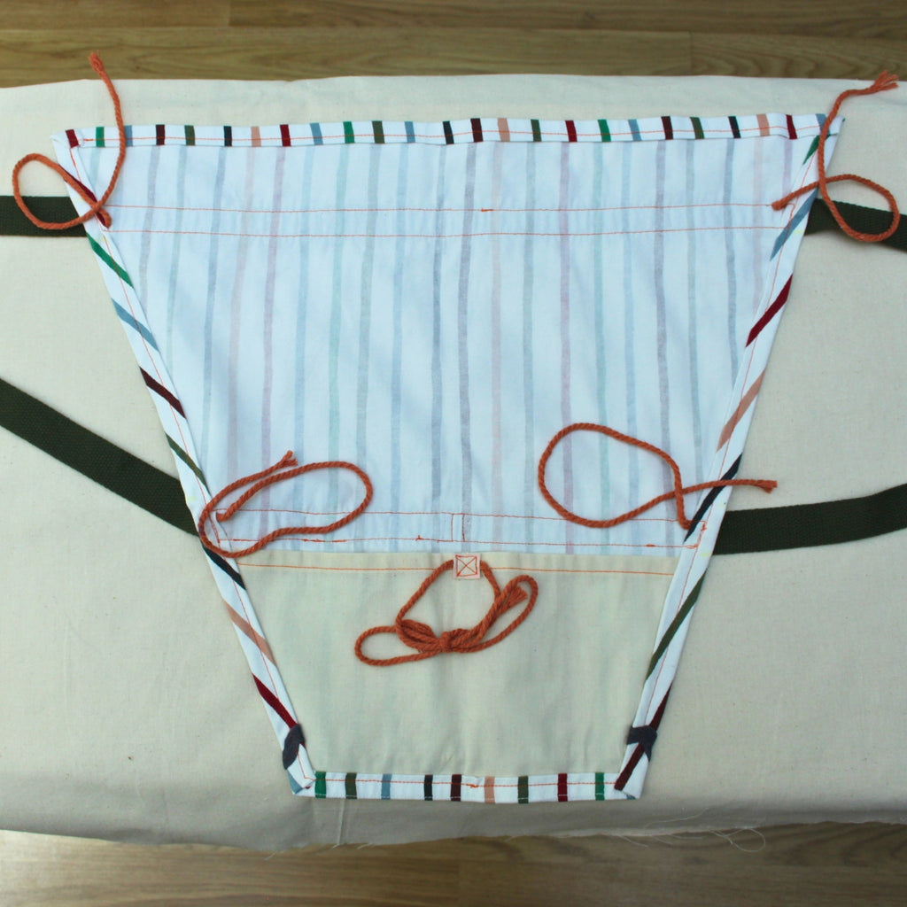 Inner lining of handmade fabric bouquet bag in multi-coloured stripes with fixed khaki strap — Dark Star Stitches