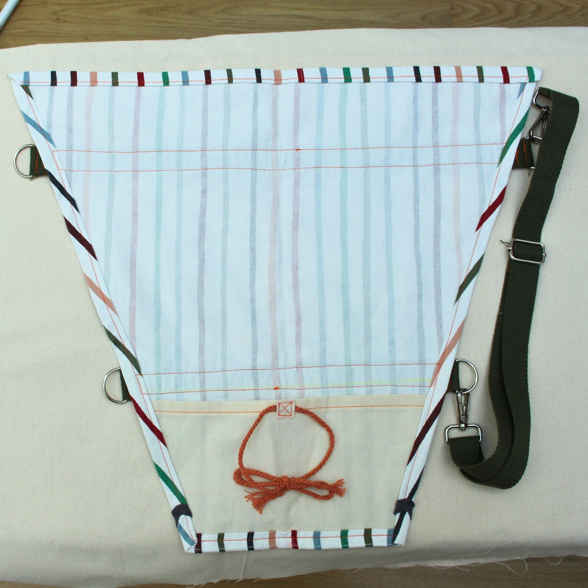Inner lining of handmade fabric bouquet bag in multi-coloured stripes with adjustable khaki strap — Dark Star Stitches