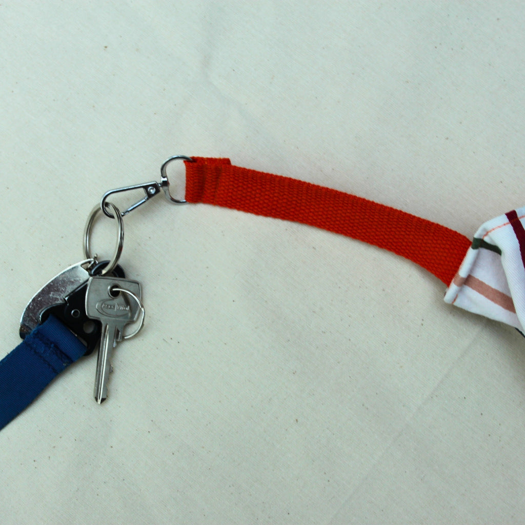 Key clip detail on handmade fabric tote bag in multi-colour stripes with blue lining and navy strap — Dark Star Stitches