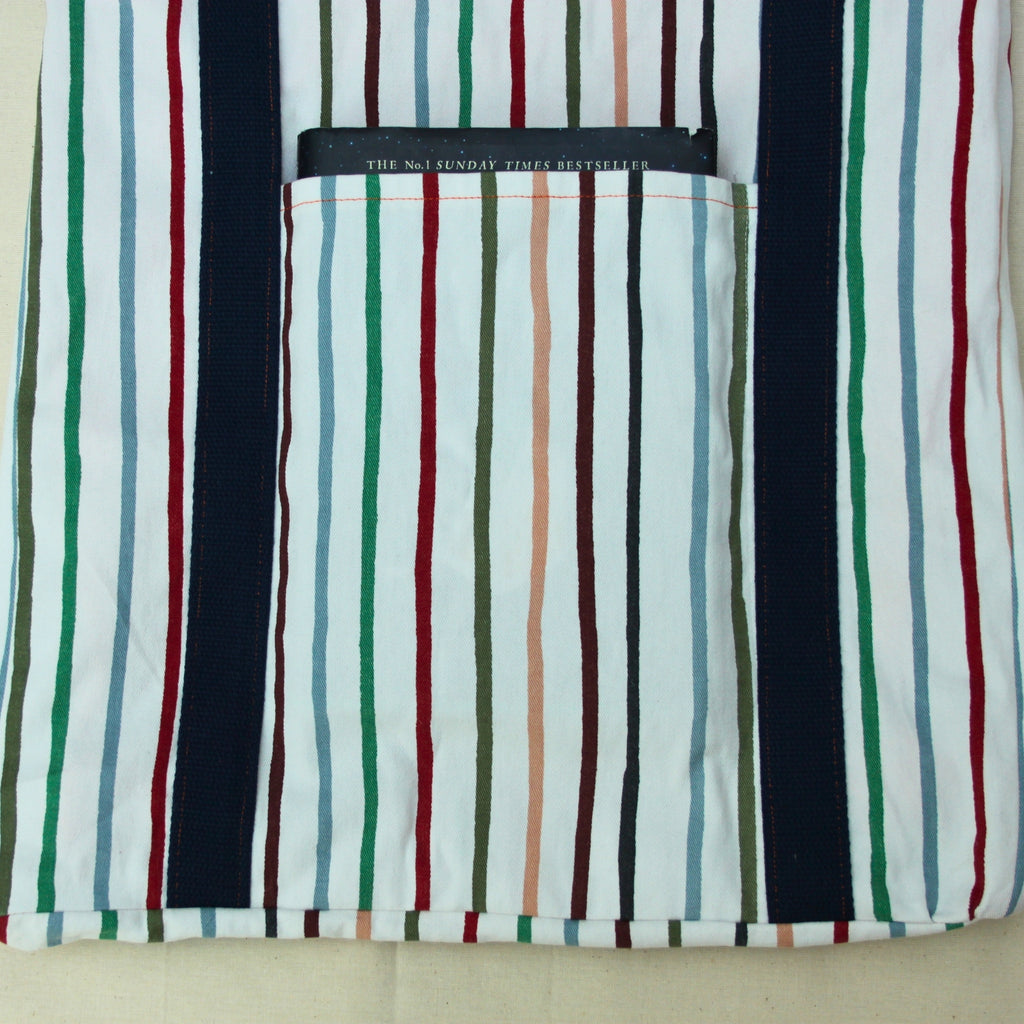 Pocket in use on handmade fabric tote bag in multi-colour stripes with blue lining and navy strap — Dark Star Stitches